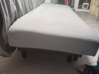 Sofá cama gris con desperfectos