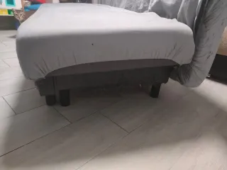 Sofá cama gris con desperfectos