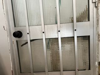 Puerta aluminio con cristal y reja