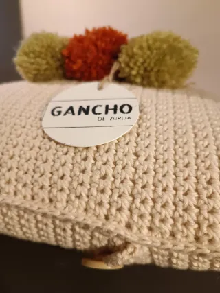 Cojín tejido a mano con pompones