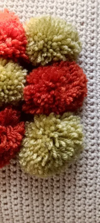 Cojín tejido a mano con pompones