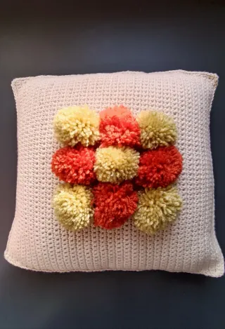 Cojín tejido a mano con pompones