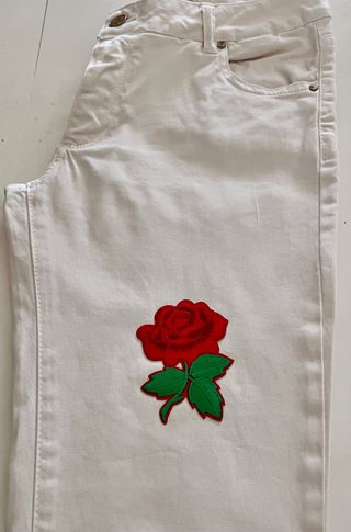 Jeans bianchi con patch rosa rossa