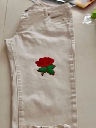 Jeans bianchi con patch rosa rossa