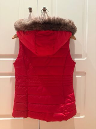 Chaleco acolchado rojo con capucha y detalle pelo.