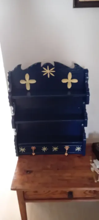 Estantería de madera azul y dorada