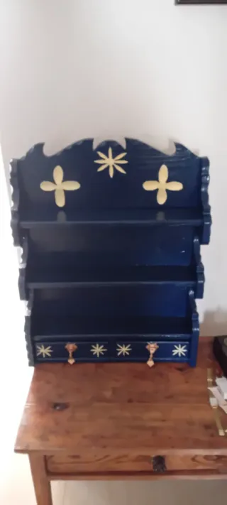 Estantería de madera azul y dorada