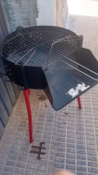 Parrilla metálica negra con patas rojas