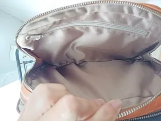 Bolso de piel marrón claro, con doble cremallera.