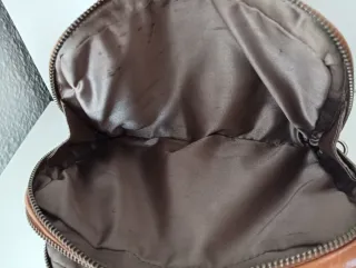 Bolso de piel marrón claro, con doble cremallera.