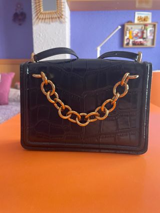 Bolso negro con cadena dorada