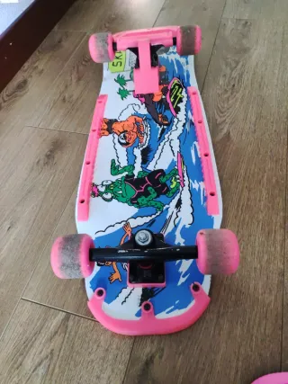 Monopatín rosa con rodilleras, coderas, casco y bo