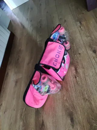 Monopatín rosa con rodilleras, coderas, casco y bo