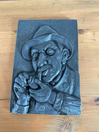 Relieve de hierro fundido hombre fumando
