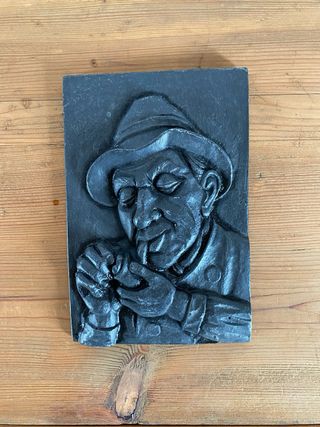 Relieve de hierro fundido hombre fumando