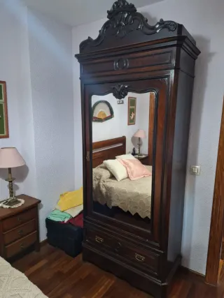 Armario antiguo de madera con espejo.