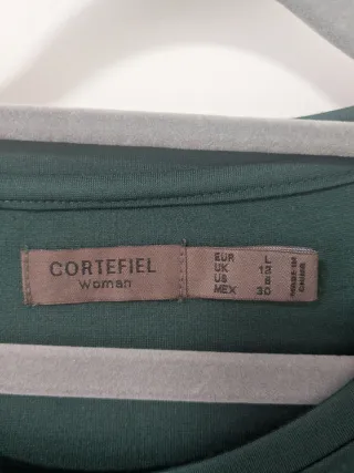 Vestido verde Cortefiel con cremalleras doradas.