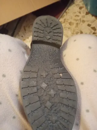 Botín piel negro con detalle metalizado.