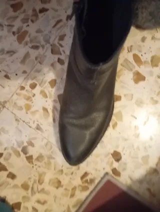 Botín piel negro con detalle metalizado.