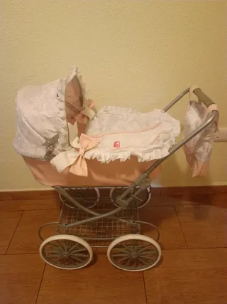 Cochecito de juguete rosa y blanco. No se envía