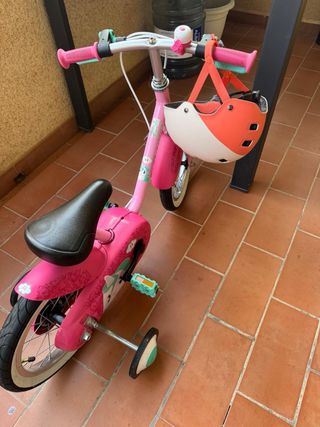 Bicicleta infantil rosa con casco