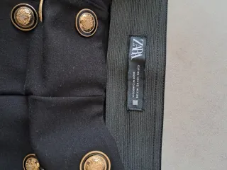 Pantalones negros con botones dorados
