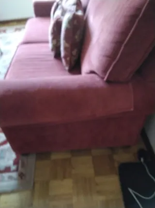 Sofá de tela rojo con cojines