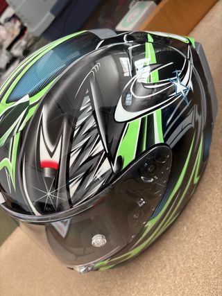 Casco de moto negro con diseño verde