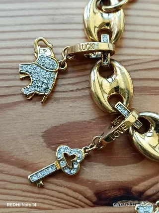 Pulseira dourada em aço com vários pendentes