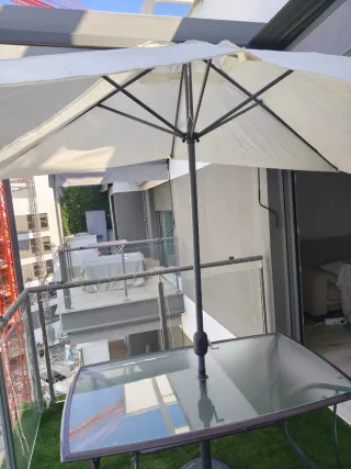 Tavolo in acciaio e vetro con ombrellone e base