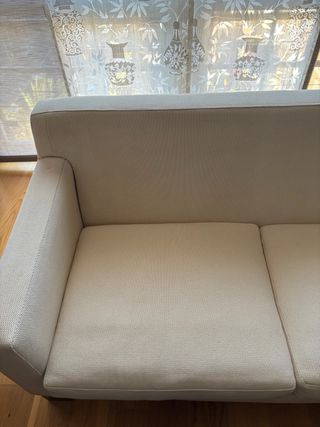 Sofá de tela beige y madera