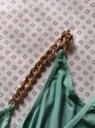 Top verde  svasato con bretelle a catena