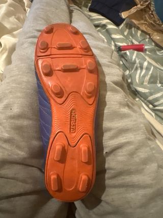 Zapatillas fútbol niño Kipsta azul y naranja.