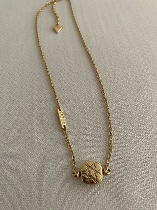 Collar Guess dorado con piedra verde aguamarina.