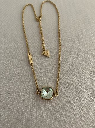 Collar Guess dorado con piedra verde aguamarina.