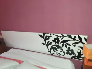 Cabecero de cama blanco con diseño floral negro