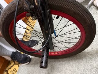 Bicicleta BMX negra con ruedas rojas