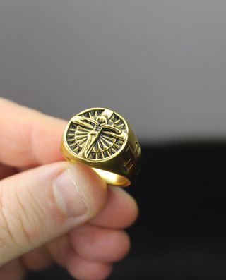 Anel de aço dourado com Cristo esculpido