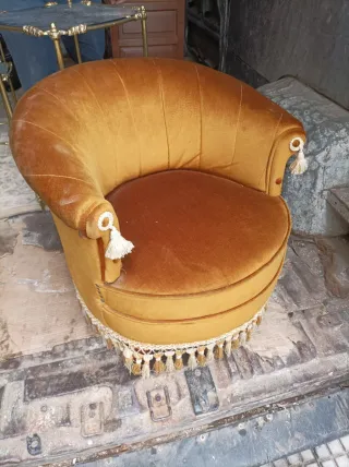 Sillón tapizado dorado con flecos