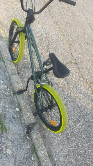 Bicicleta BMX verde con ruedas amarillas