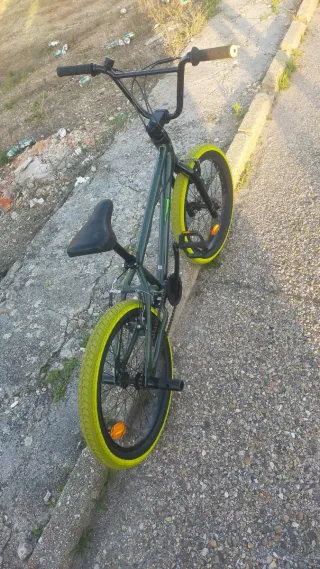 Bicicleta BMX verde con ruedas amarillas