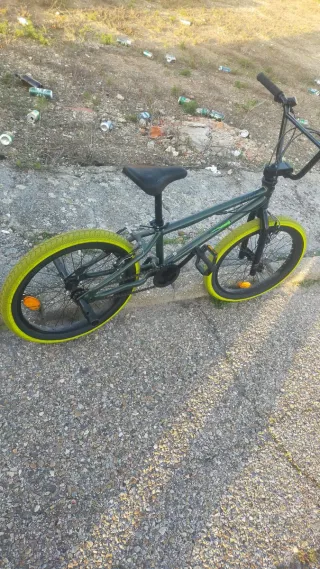 Bicicleta BMX verde con ruedas amarillas