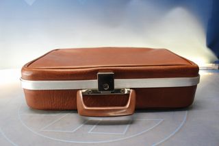 Pequeña maleta vintage en cuero marrón.