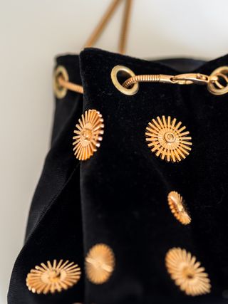 Bolso saco negro con adornos dorados