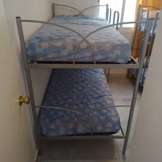 Litera de hierro color plata y colchones .