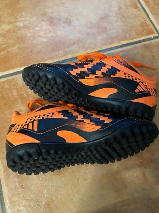 Botas de fútbol naranjas y negras para niños/as