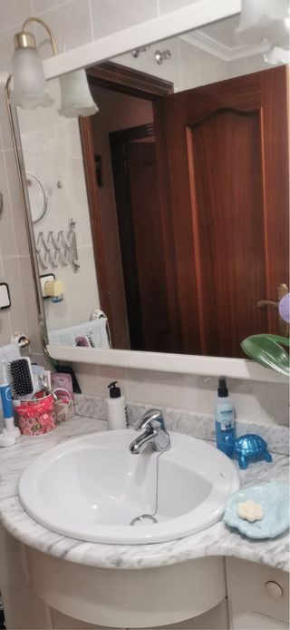 Mueble de baño con espejo y lavabo.