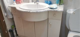 Mueble de baño con espejo y lavabo.