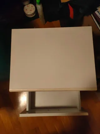 Mesita de noche blanca con dos cajones y ruedas.