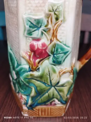 Antica caraffa in ceramica vintage con foglie e frutti